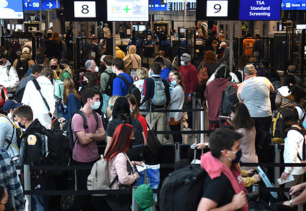 People are seen in a TSA security checkpoint line at Orlando International Airport two days before Christmas.
Due to the increase and the spread of covid-19 and Omicron variant infections, holiday travelers are taking extra precautions by getting tested for the virus before gathering with family and friends.