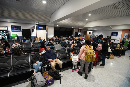 People wait for their flight at the boarding gate at Oakland International Airport during Christmas holiday.