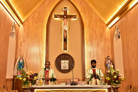 Christian priests are seen at the altar of the Holy Family Catholic Church during the Christmas Eve mass.