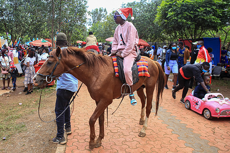 A kid wearing a Santa Claus hat riding a horse on Christmas day.
Nairobi residents spent their Christmas day at the Uhuru and Central parks every year. However, this year due to the temporary closure of the two parks, the residents look for small spaces that were available in the area to continue its Christmas tradition.