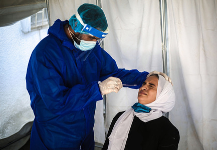 A health worker collects a specimen from a woman through a Covid-19 nasal swab test to determine if she is infected by the emerging covid-19, at a clinic in the southern Gaza Strip. 
On December 27, 2021, the Palestinian Ministry of Health in Gaza City has announced that the first case of covid-19 variant, "Omicron" was detected in Gaza Strip.
