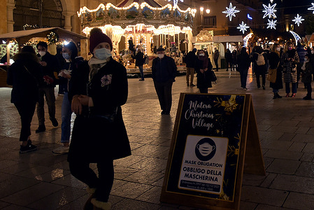 People walk in the "Matera Christmas Village", a Christmas market, set up in the center of the city of Matera.