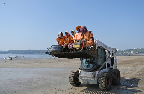 Women marshals riding on a beach clean up vehicle at Versova beach.
Beach clean up marshals are hired to keep the city beaches clean of garbage and plastic waste.