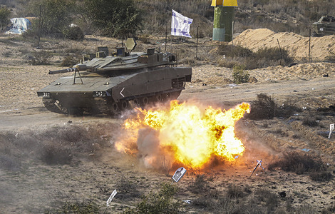 An explosion seen close to a fake Israeli tank during the "Al -Rokn Al Shadeed 2" military drill organised by the Palestinian military wings factions in Rafah, southern Gaza Strip.