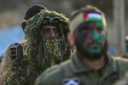 Palestinian militant with a painted face takes part during a military drill organized by the military factions in Rafah, southern Gaza Strip.