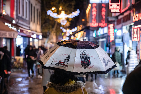 A woman seen walking with an Istanbul-themed umbrella on a rainy day at the Kadikoy bazaar.