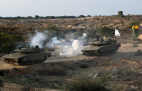 An explosion seen between fake Israeli tanks during the "Al -Rokn Al Shadeed 2" military drill organised by the Palestinian military wings factions in Rafah, southern Gaza Strip.