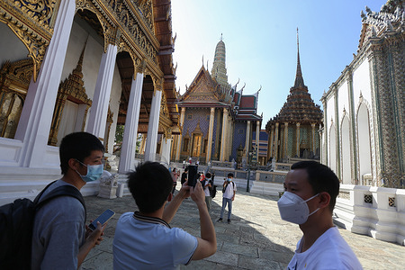 Tourists wearing facemasks as a preventive measure against the spread of coronavirus are seen at the Emerald Buddha Temple inside the Grand Palace in Bangkok.