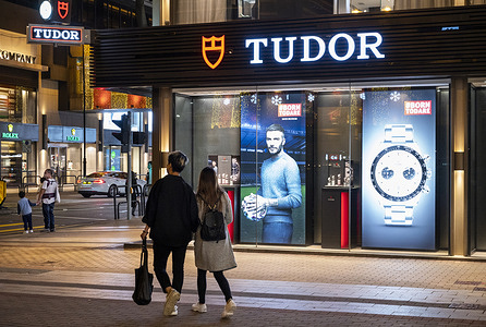 Pedestrians walk past a Swiss watchmaker manufacturer and brand Tudor store in Hong Kong.