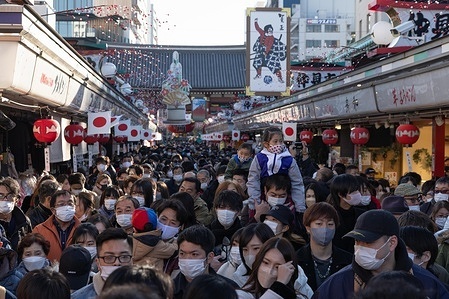 Crowds of visitors wearing masks head towards the main hall of Sensō-Ji Temple in Asakusa during Hatsumode.
Hatsumode is the Japanese tradition of visiting a shrine or temple for the first time in the New Year. On this occasion, people pray for good fortune and health in the year ahead.