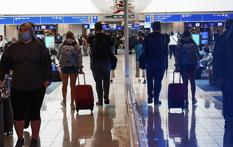 Travelers make their way through Orlando International Airport on New Year's weekend, despite thousands of flight cancellations and delays across United States.