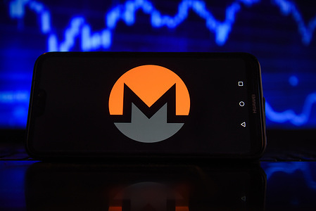 In this photo illustration a Monero logo seen displayed on a smartphone with stock market percentages in the background.