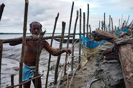 An old man is seen rebuilding the wooden fence of his house which was broken by high tides at the coastal area of Jaymani village.
Bangladesh is one of the countries that is the most vulnerable to the effects of climate change. Bangladesh suffered from tropical cyclones, high tides, river erosion, flood, landslides, and drought which are all increasing in intensity and frequency due to climate change.
