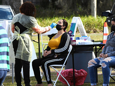 A health care worker collects swab sample from a woman at a testing site at Edwards Field in Apopka in Florida after Covid-19 Omicron variant surges in Florida and across the country.
Testing sites in the Orlando area are reaching capacity on a daily basis after 85,000 new Covid-19 cases are recorded in Florida for the past weekend.