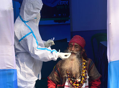 A monk is being tested for Covid-19 at a Gangasagar Transit Camp before heading to the Gangasagar mela in sagar island.