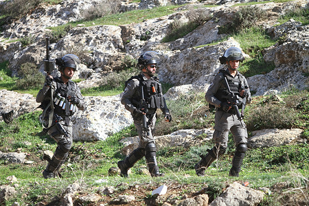 Israeli soldiers chase Palestinian protesters during a demonstration against Israeli settlements in the village of Beit Dajan near the West Bank city.