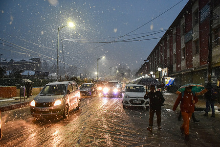 Residents shelter under their umbrellas while walking along the street during a snowfall in Srinagar.
The weather forecast has predicted heavy to intense rainfall or snowfall in Jammu & Kashmir on the 7th and 8th of January.