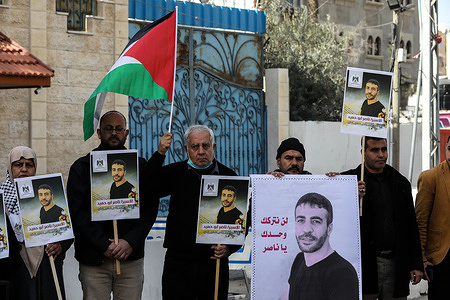 Palestinians hold portraits of the sick prisoner Nasser Abu Hamed, during a solidarity demonstration in Gaza City, to release him to enable him to receive the necessary treatment, as he suffers from a critical health condition in the Israeli Barzilai Hospital.