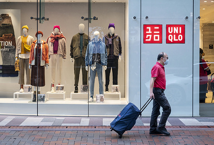 A pedestrian walks past the Japanese clothing brand store Uniqlo store in Hong Kong.