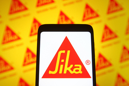 In this photo illustration, a Sika AG logo is seen on a smartphone screen and in the background.