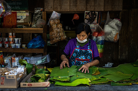 Street food vendor makes bowls from banana leaves.
Daily Life in a Mae Kampong, a small village located in the Mae On District of Chiang Mai Province. Mae Kampong, an agriculturally diverse town, has become well-known for its agriculture, home stays and approach to sustainable eco-tourism.