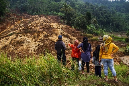 Residents stand near a landslide area in Ciherang Village, South Sumedang.
Landslide from a cliff resulted in two hectares of rice fields buried in the ground and residents of a block in the hamlet forced to evacuate.