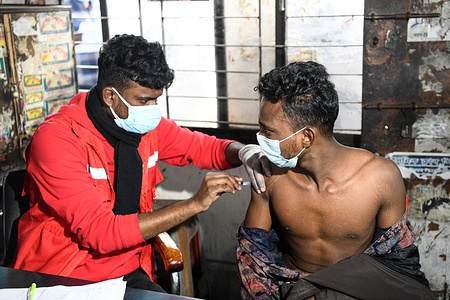 A health worker administers a COVID-19 vaccination shot to a public transport driver during the crash program at Mohakhali bus terminal in the capital.
In the crash program, public transport drivers and workers are given coronavirus vaccination starting in the capital. Vaccination is done by showing national identity card or birth registration.