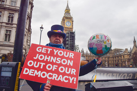 Activist Steve Bray holds an anti-Boris Johnson placard and a balloon with 'Party's Over' written on it, during the demonstration.
Protesters gathered outside the Houses of Parliament as Boris Johnson faced Prime Minister's Questions (PMQs) and calls to resign over the Downing Street lockdown parties.