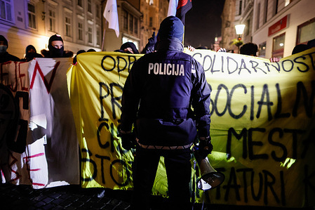 A police officer stands in front of protesters holding banners during the demonstration.
On the first anniversary of the controversial evictions of artists and cultural centers at the squatted old Rog bicycle factory in Ljubljana, protesters hold a demonstration against the increasing privatization and the commercialization of public spaces and social cleansing of the city. With this development, the citizens particularly those with low income are forced to leave the area.
